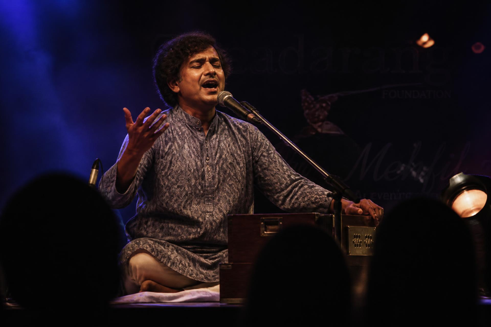 Rahul Deshpande performing live under stage lighting